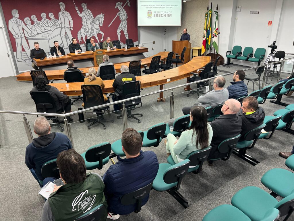 A Prefeitura de Erechim, por meio das secretarias de Obras, Habitação e Segurança Pública e de Desenvolvimento Econômico, Inovação e Turismo, realizou na manhã desta segunda-feira (22), na Câmara de Vereadores, a Audiência Pública de apresentação e discussão das propostas de alterações em eixos urbanos e zoneamento previstas no Plano Diretor do município. As mudanças em análise atendem demandas de empresas já instaladas em Erechim, que buscam ampliação de suas estruturas produtivas. O objetivo é compatibilizar o crescimento econômico com o planejamento urbano, fortalecendo a geração de empregos, a expansão da atividade industrial e o desenvolvimento sustentável do município. O Plano Diretor é o principal instrumento de planejamento urbano de Erechim, responsável por estabelecer diretrizes para o crescimento e desenvolvimento da cidade. A legislação define regras para o uso e ocupação do solo, organização dos bairros, mobilidade urbana, preservação ambiental, atividades econômicas e expansão urbana, buscando garantir um desenvolvimento equilibrado e sustentável. Por isso, qualquer alteração em eixos urbanos ou zoneamento exige análise técnica, debate com a comunidade e apreciação do Poder Legislativo.